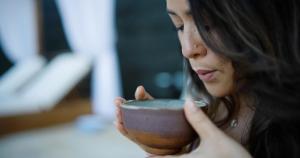 a woman is drinking from a brown bowl at Wailea Beach Resort - Marriott, Maui in Wailea