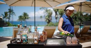 a woman standing in front of a table with drinks at Wailea Beach Resort - Marriott, Maui in Wailea