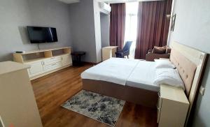 een hotelkamer met een bed en een televisie bij LAMIYA Aparts Hotel in Alma-Ata