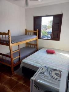 a bedroom with two bunk beds and a window at Pousada Chalés Vereda do Sol in Ubatuba