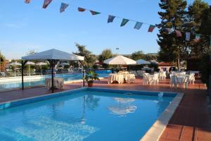 a swimming pool with tables and chairs and a restaurant at IRON GATE MARINA3B in Sarzana