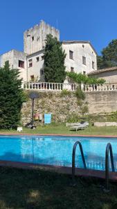 a swimming pool with a castle in the background at La Torre de Vilanna in Bescanó +27 photos