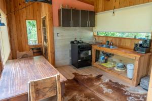 a kitchen with a wooden table and a stove at Casita del Arbol Santa Clara in San Carlos de Bariloche