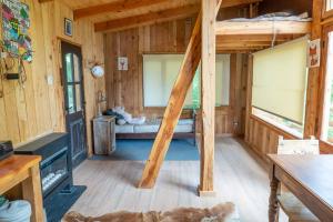 a room with a bed in a wooden cabin at Casita del Arbol Santa Clara in San Carlos de Bariloche