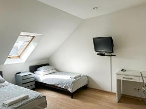 a bedroom with two beds and a tv on the wall at Pokoje na Jasełkowej in Szczecin