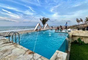 a swimming pool next to the beach with people in it at Avanti Zorritos in Bocapán