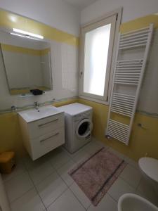 y baño con lavadora y lavamanos. en I tigli Pomposa, en Lido di Pomposa