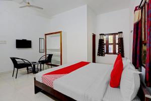 um quarto com uma cama, uma mesa e um espelho em OYO K B Residency em Chennai