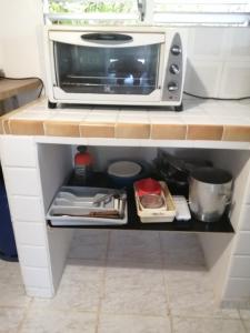 a microwave oven sitting on top of a kitchen counter at chez arlette in Petit-Bourg