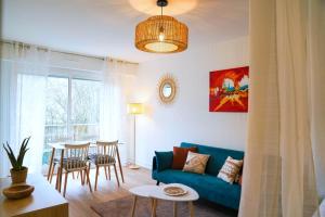 a living room with a blue couch and a table at Douceur Angevine in Angers