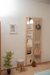 Cette chambre comprend un placard avec un miroir et un tabouret. dans l'établissement Tsaner Apartment and Rooms, à Matala