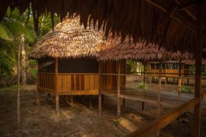 a hut with a straw roof and a bench at Eywa Lodge Amazonas - All inclusive in Yucuruche +61 photos