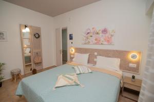 a bedroom with a large bed with a blue blanket at Tsaner Apartment and Rooms in Matala
