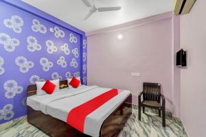 a bedroom with a large bed and a chair at Hotel O Heritage Inn in Cuttack
