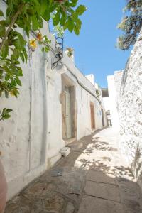 an alley with a white building with a door at Patmos Traditional House Chora near the Monastery in Patmos +61 photos