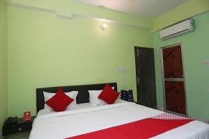 sypialnia z łóżkiem z białymi i czerwonymi poduszkami w obiekcie Flagship Near Anisabad Golambar w mieście Patna