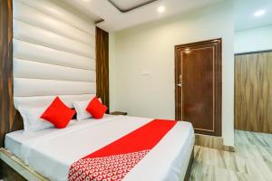 1 dormitorio con 1 cama con almohadas rojas en 75217 Hotel Navya Grand, en Gulzārbāgh