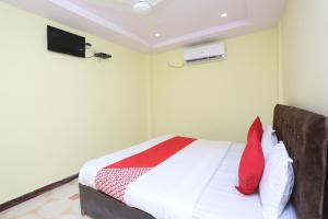1 dormitorio con 1 cama y TV en la pared en Hotel Manoj, en Jāmul