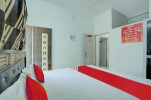 a bedroom with a large white bed with red accents at Flagship Hotel Pragya 3 New in Raipur
