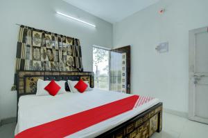 a bedroom with a large bed with red pillows at Flagship Hotel Pragya 3 New in Raipur