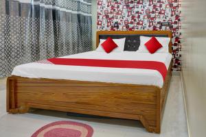 1 dormitorio con cama de madera y almohadas rojas en Flagship Sk Brother Hotel en Patna