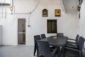 einen Tisch mit Stühlen und eine Uhr an der Wand in der Unterkunft Casa turística Cunit in Cunit