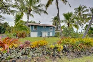 una casa azul con palmeras y un jardín en Breezy Kailua-Kona Bungalow with Lanai and Ocean View! en Kailua-Kona