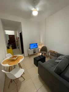 ein Wohnzimmer mit einem Sofa und einem Tisch in der Unterkunft Apartamento Aconchegante em Copacabana a 100 Mts da Praia in Rio de Janeiro