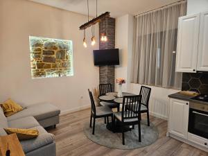 a kitchen and living room with a table and chairs at Cozy apartament in Sighetu Marmaţiei