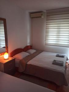 1 dormitorio con 2 camas y una lámpara en una mesa en Apartman Tristan, en Herceg-Novi