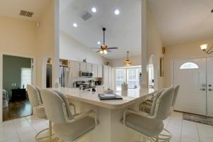a kitchen with a large island with chairs around it at Crystal River Vacation Rental on Canal! in Crystal River