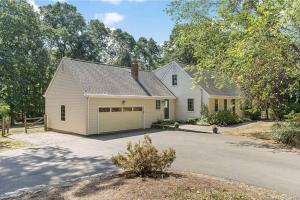 a white house with a garage on a street at White Oaks in Branford