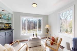 a living room with two chairs and a table and two windows at White Oaks in Branford