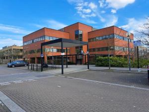 un bâtiment en briques avec un arrêt de bus en face de celui-ci dans l'établissement Luxury 2 Bedroom Charter House, à Milton Keynes