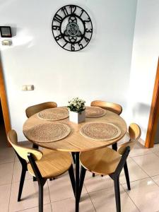 drewniany stół z krzesłami i zegar na ścianie w obiekcie Blue Beach Apartment+Oceanview+Private Parking w Walencji