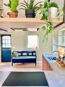 een woonkamer met een bank en een aantal planten bij 30 steps to sand.. Light and spacious family villa in Zandvoort
