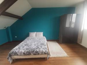 a bedroom with a bed and a blue wall at Appartement entier à Sevran in Sevran