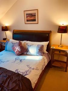 a bedroom with a bed with two lamps and a night stand at Mulberry in Nairn