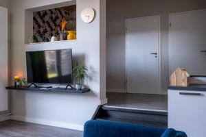 a living room with a tv and a blue couch at @ geulle in Guelle
