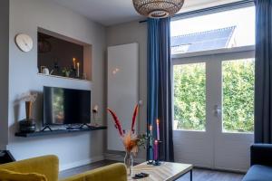 a living room with a couch and a table and a window at @ geulle in Guelle