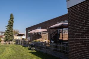 a patio with tables and umbrellas on a brick building at @ geulle in Guelle