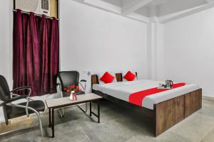 a bedroom with a bed and a table and chairs at Hotel O Star Stay Guest house opposite Kendriya Bhawan in Lucknow