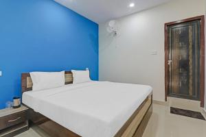 a bedroom with a large bed with a blue wall at OYO Hotel Rudra Palace Near Phoenix United Lucknow in Charbagh