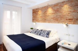 a bedroom with a white bed and white walls at Feelathome Center Apartments in Barcelona