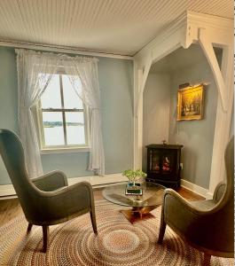 a living room with two chairs and a table and a window at Orcas Hotel in Orcas