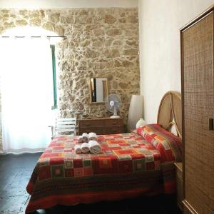 a bedroom with a bed and a stone wall at Casa Vacanze Magnolia in Punta Secca