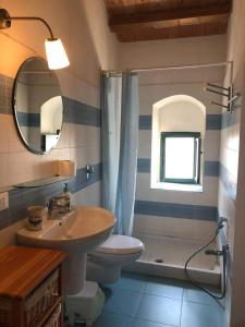 a bathroom with a sink and a toilet and a mirror at Casa Vacanze Magnolia in Punta Secca