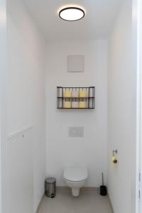 baño blanco con aseo y ventana en Luxurious apartment with big balcony near city center, en Viena