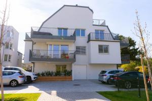 una casa blanca con coches aparcados en un estacionamiento en Luxurious apartment with big balcony near city center, en Viena