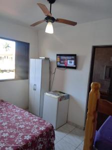 a room with a refrigerator and a ceiling fan at Pousada Chalés Vereda do Sol in Ubatuba